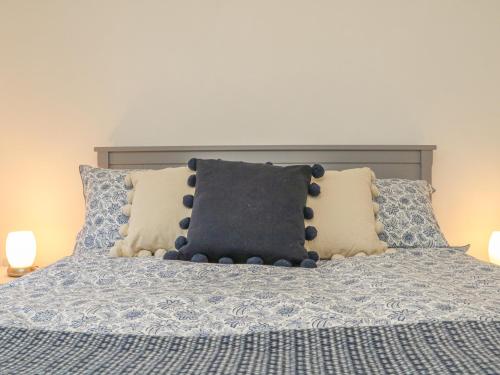 a bed with a pillow on it with two pillows at Tidewood in Bideford