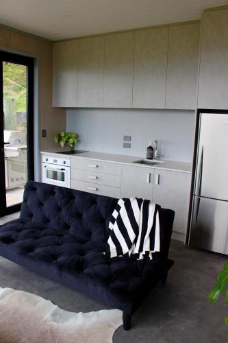 a living room with a couch in a kitchen at The Beach House on the Hill in Raglan