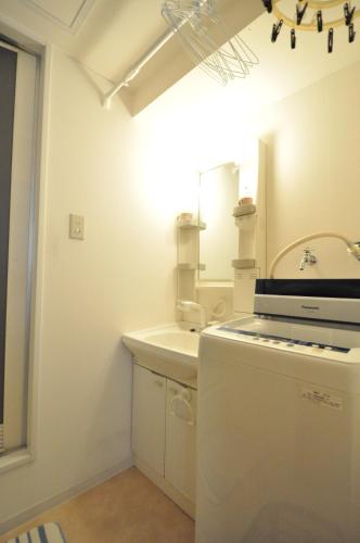 a small white bathroom with a sink and a sink at Downtown area Spacious cozy room Susukino IK301 in Sapporo