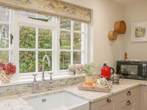 a kitchen with a sink and two windows at Rookwood in Exeter