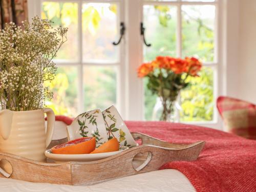 a tray of fruit on a table with a vase of flowers at Rookwood in Exeter
