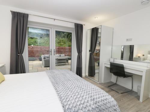 a bedroom with a bed and a desk and a television at The Office Gardens, Apartment 1 in Whitby