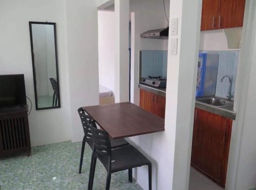 a small kitchen with a wooden table and a chair at Cool Stay Inn in Boracay