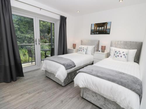2 camas en un dormitorio con ventana en The Office Gardens, Apartment 2, en Whitby