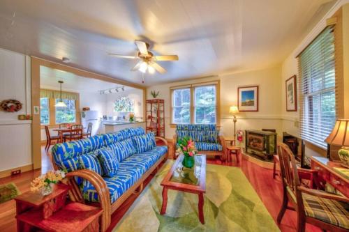 a living room with a blue couch and a table at Tutu's Place by Volcano Heritage Cottages in Volcano