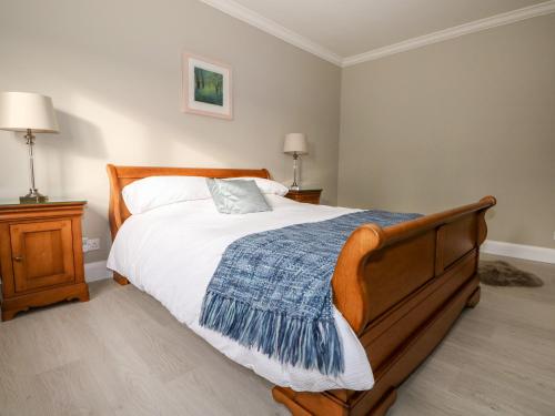 a bedroom with a bed with a blue blanket on it at Roughwood in Ringwood