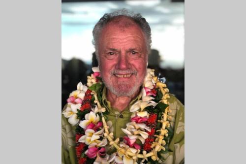 an older man wearing a necklace of flowers at Ola'a House by Volcano Heritage Cottages in Volcano