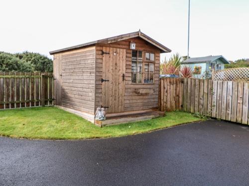 a small wooden shed with a dog sitting in it at Seaview in Coleraine