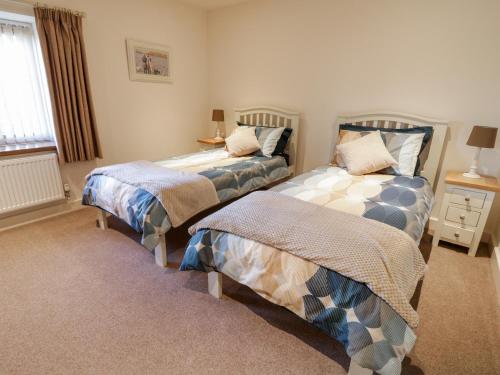 a bedroom with two beds and a window at Grange Cottage in Crediton