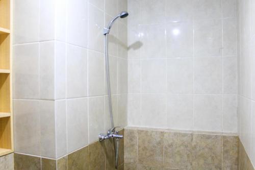 a shower with a glass door in a bathroom at New Furnished 2BR Apartment at Silkwood Residence By Travelio in Tangerang