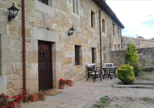 un patio con 2 sillas y una mesa junto a un edificio en Casa Rural S. Antonio, en Menaza