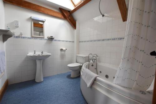 uma casa de banho com um lavatório, uma banheira e um WC. em Stable Cottage em Newport