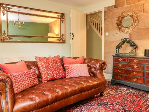brązowa skórzana kanapa w salonie z lustrem w obiekcie Richfield w mieście Matlock