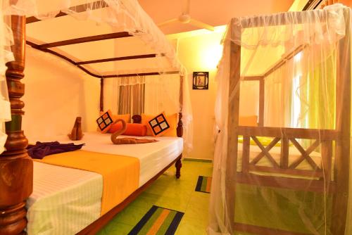 a bedroom with a bed and a canopy bed at Peacock Beach Hotel Unawatuna in Unawatuna