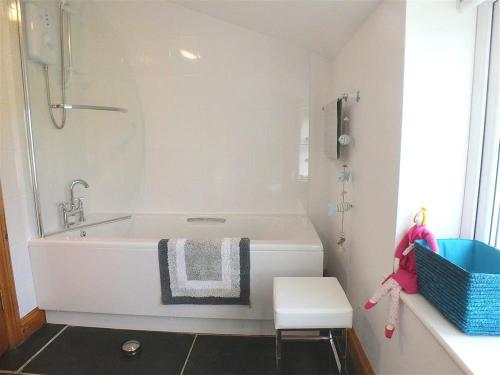 La salle de bains est pourvue d'une baignoire avec douche et d'un tabouret. dans l'établissement Gwndwn Gwyn, à Goodwick