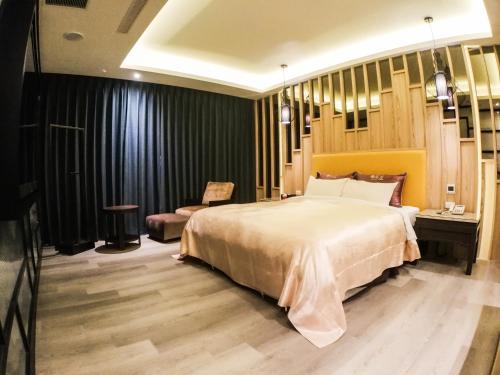 a bedroom with a large bed and a chair at Song Xia Motel in Dali