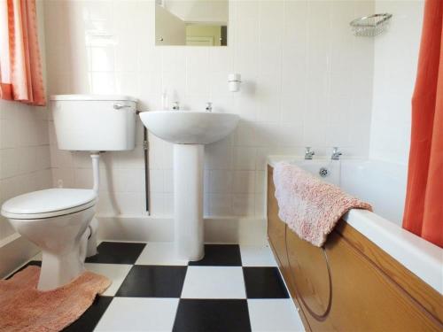 a bathroom with a toilet and a sink and a tub at Granston Cottage in Granston