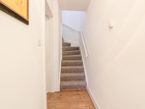 a staircase in a home with white walls and wooden floors at 1 Alpine Place in Thornhill