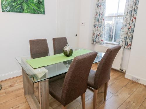 a dining room with a glass table and chairs at 1 Alpine Place in Thornhill