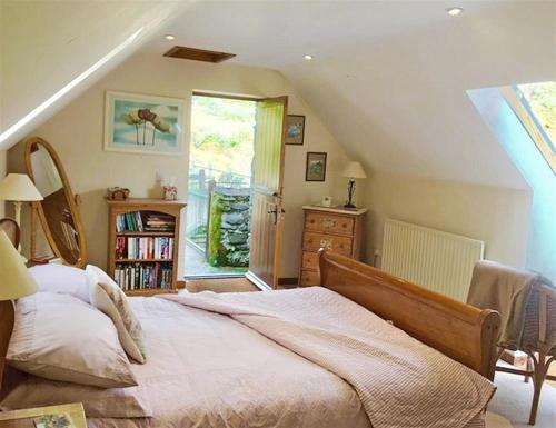 a bedroom with a large bed in a attic at Upper Barn Cottage in Aberangell