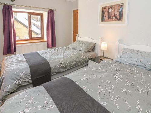 two beds sitting next to each other in a bedroom at Rose Cottage in Grange Over Sands