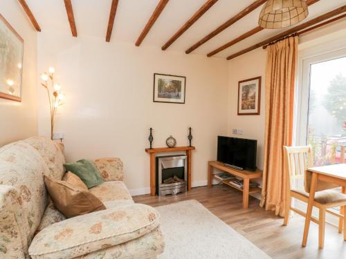 a living room with a couch and a tv at Woods Edge in Mitcheldean