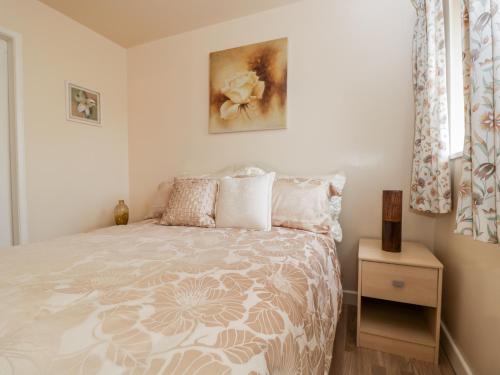 a bedroom with a bed with a flowery bedspread at Woods Edge in Mitcheldean