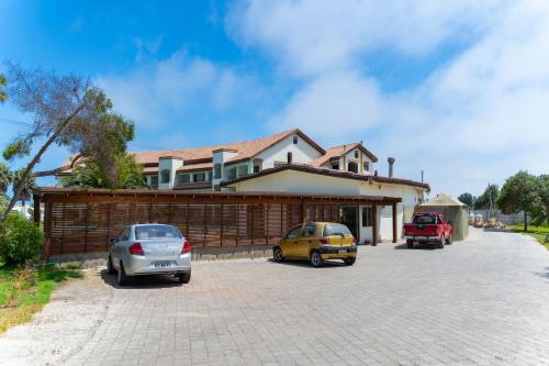 a house with two cars parked in a driveway at Hotel Palmas de La Serena in La Serena
