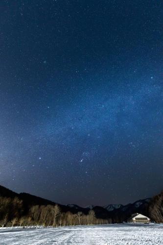 a starry night over a snow covered field at LiVEMAX RESORT Hakodate Greenpia Onuma in Mori