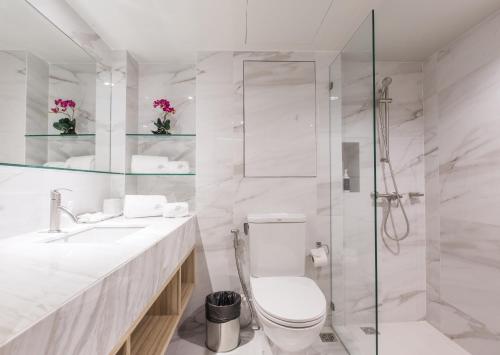 バンコクにあるS.D. アベニュー ホテルの白いバスルーム(トイレ、シャワー付)