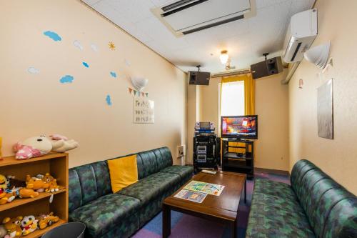 a living room with couches and a tv at LiVEMAX RESORT Hakodate Greenpia Onuma in Mori