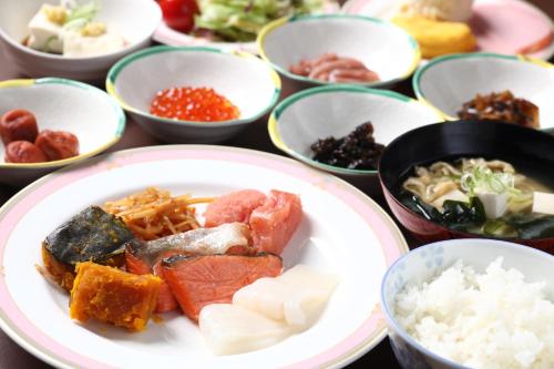 a plate of food on a table with bowls of food at LiVEMAX RESORT Hakodate Greenpia Onuma in Mori