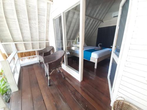 a view of a room with a bed and a mirror at Living Trawangan Hotel in Gili Trawangan