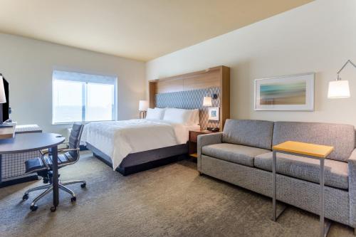 Habitación de hotel con cama y sofá en Holiday Inn & Suites Cedar Falls-Waterloo Event Ctr, an IHG Hotel en Cedar Falls
