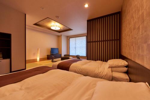 a bedroom with two beds and a television in it at Niseko Prince Hotel Hirafutei in Niseko