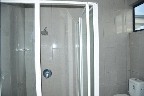 a shower with a glass door in a bathroom at Best View Apartments in Nadi