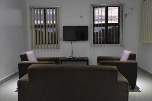 a living room with two chairs and a flat screen tv at Best View Apartments in Nadi