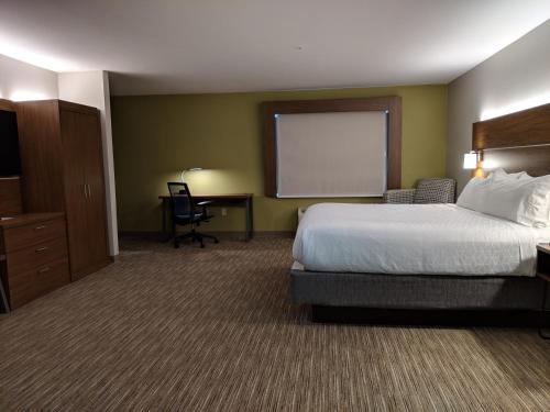 a hotel room with a bed and a projection screen at Holiday Inn Express Hotel & Suites Claypool Hill -Richlands Area by IHG in Pounding Mill