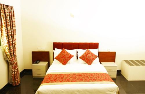 a bedroom with a large bed with red pillows at Nilakma Lagoon in Negombo