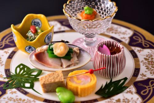 a table topped with plates of food on a table at Muromachi Yutone Kyokoyado in Kyoto