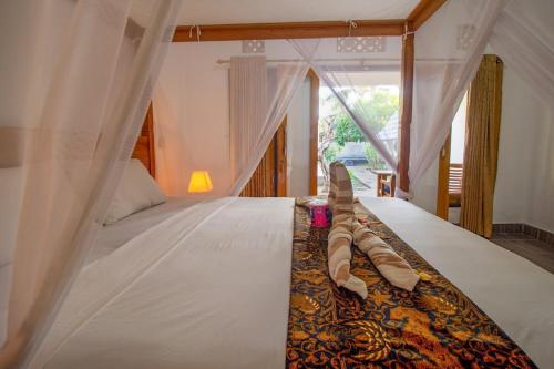 En eller flere senge i et værelse på Balengku Homestay