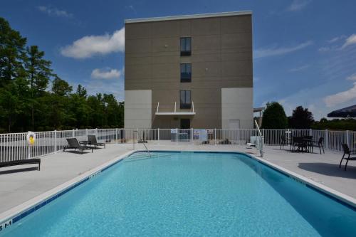 a swimming pool in front of a building at Holiday Inn Express & Suites Raleigh Durham Airport at RTP, an IHG Hotel in Durham