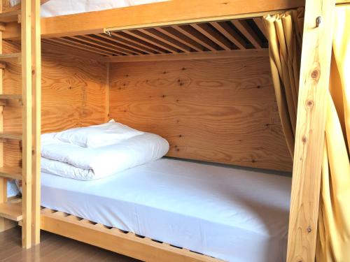 a bunk bed in a wooden bunk room at ゲストハウスぷれぜんと in Tokyo