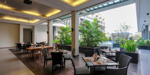 a restaurant with tables and chairs in a building at ILLIRA Lite Praya Lombok in Praya