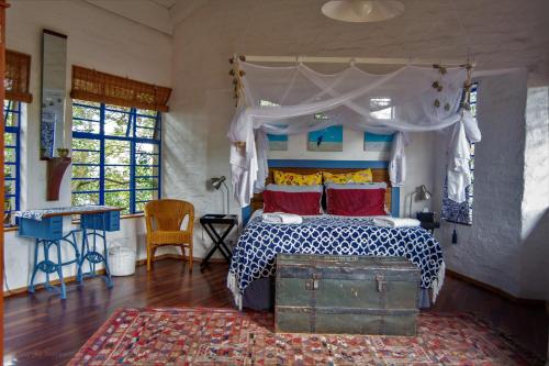 a bedroom with a bed with a canopy and a rug at Artist's Attic in Nelspruit