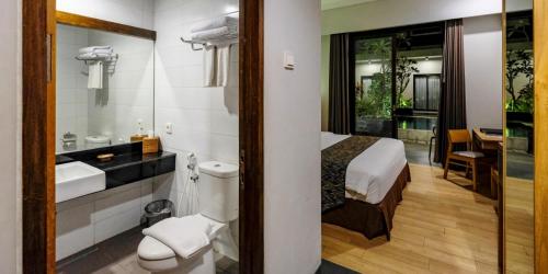 uma casa de banho com uma cama, um lavatório e um WC. em ILLIRA Lite Praya Lombok em Praya