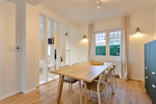 a dining room with a wooden table and chairs at Maison Lucie in Koksijde