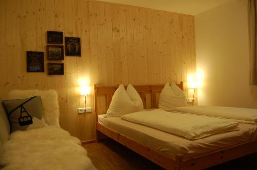 two beds in a room with two lights on at Landhaus Neussl in Kaltenbach