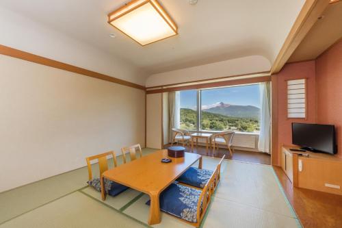 a dining room with a table and a television at LiVEMAX RESORT Hakodate Greenpia Onuma in Mori