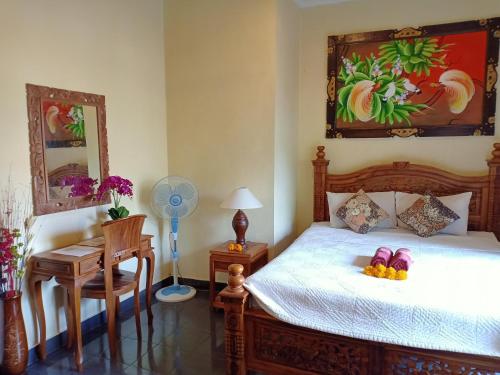 - une chambre avec un lit, une table et un bureau dans l'établissement Pondok Taman Asri Homestay, à Ubud